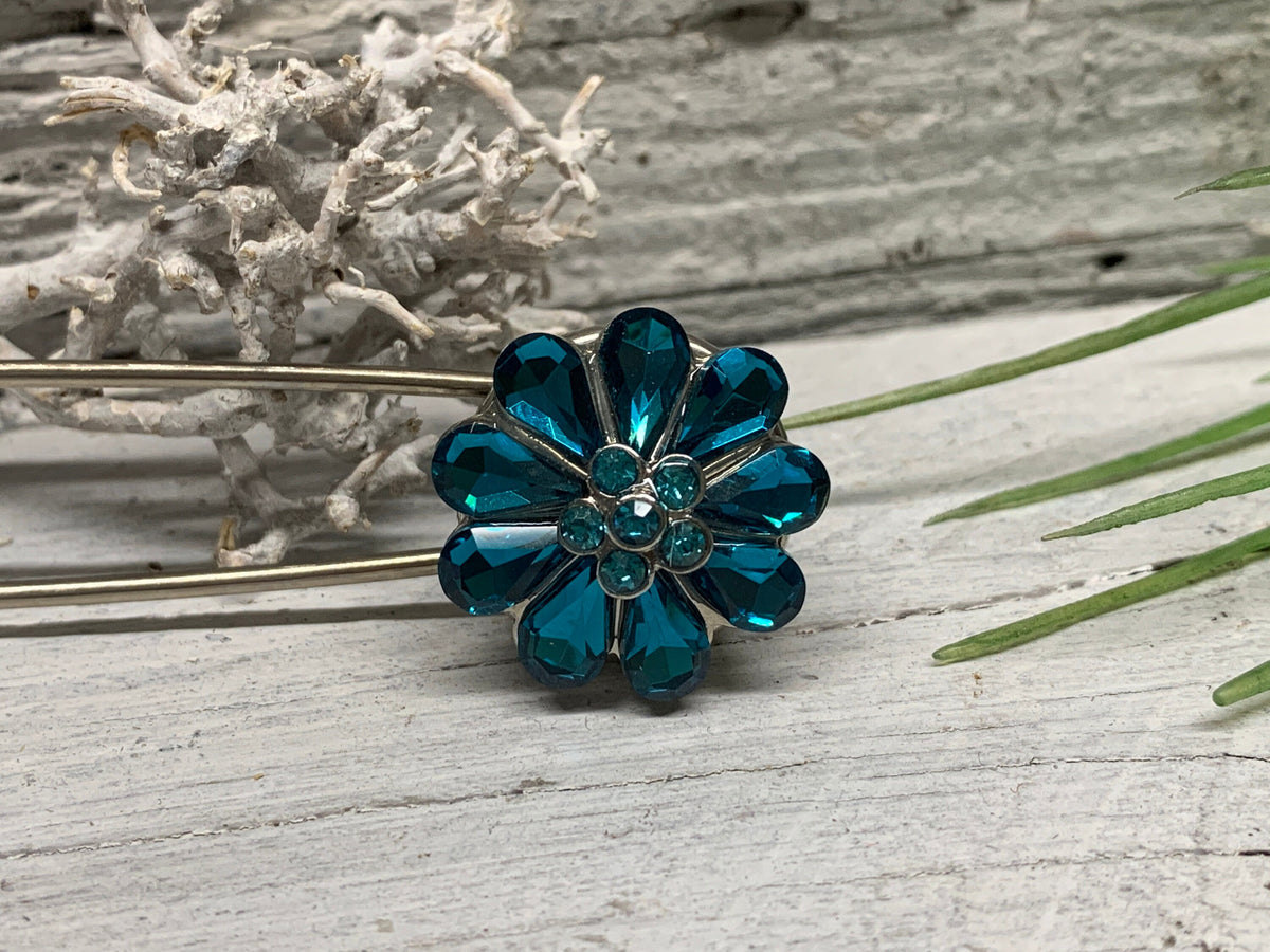 Kiltnadel mit Strass-Blume in Seitenansicht auf grauem Holz