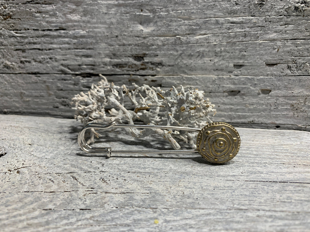 Ponchonadel mit abstrakter Rose in Silber- und Goldtönen auf verwittertem Holz vor Trockenflechte