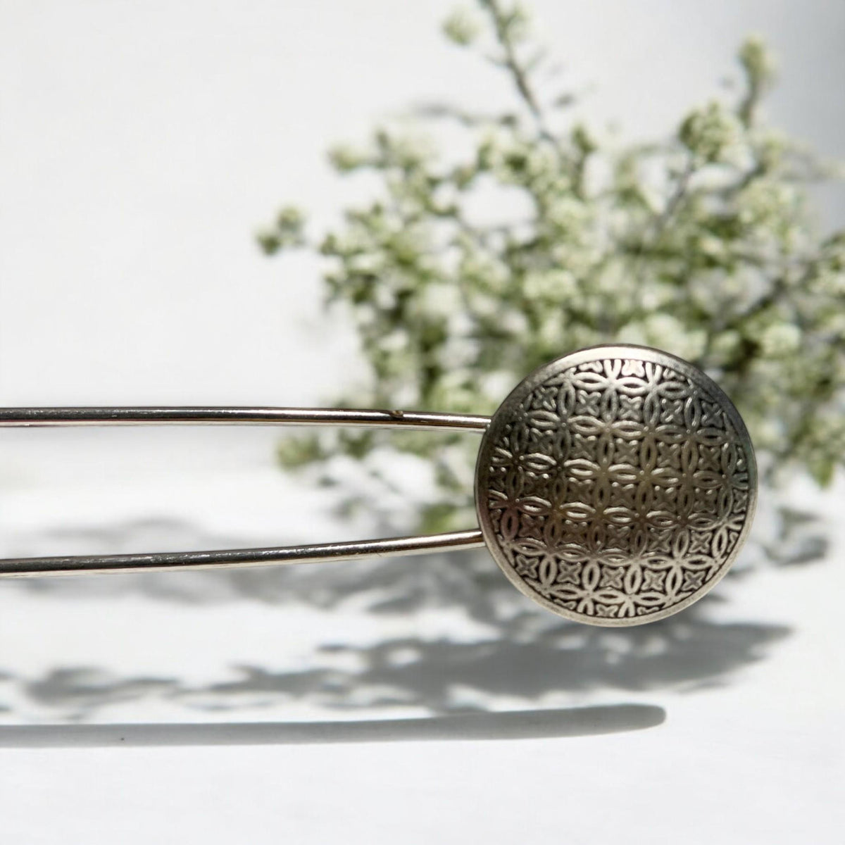 Ponchonadel mit Blume des Lebens vor weißen Blüten