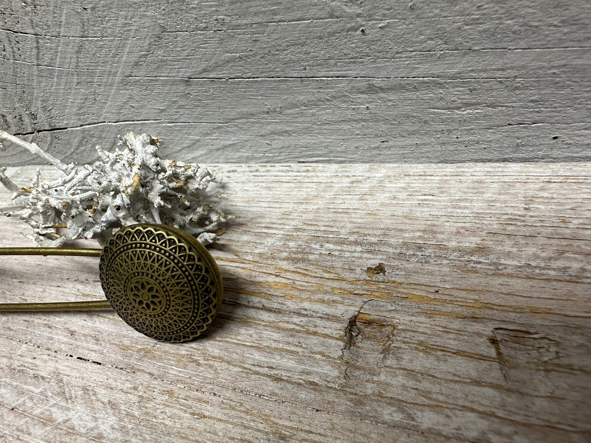 Ponchonadel mit Ornament in Seitenansicht auf hellem Holz