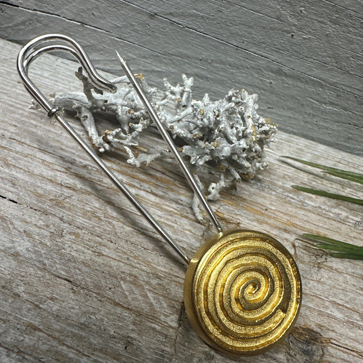 Geöffnete Ponchonadel mit goldfarbener Spirale