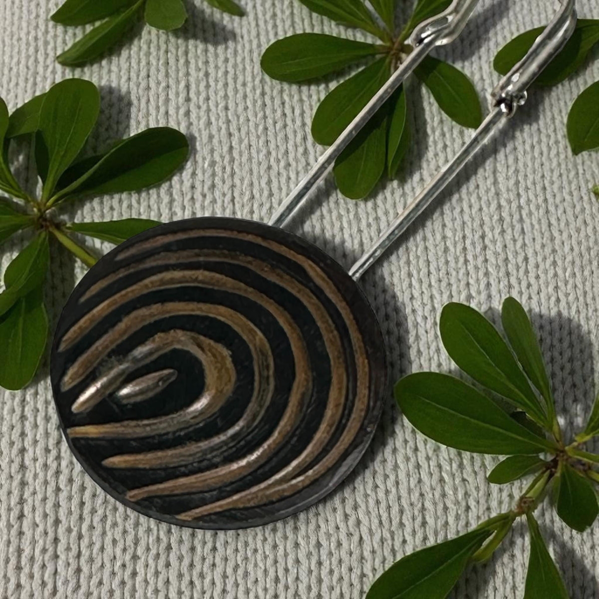 Ponchonadel mit Holz-Spirale an grauem Strick