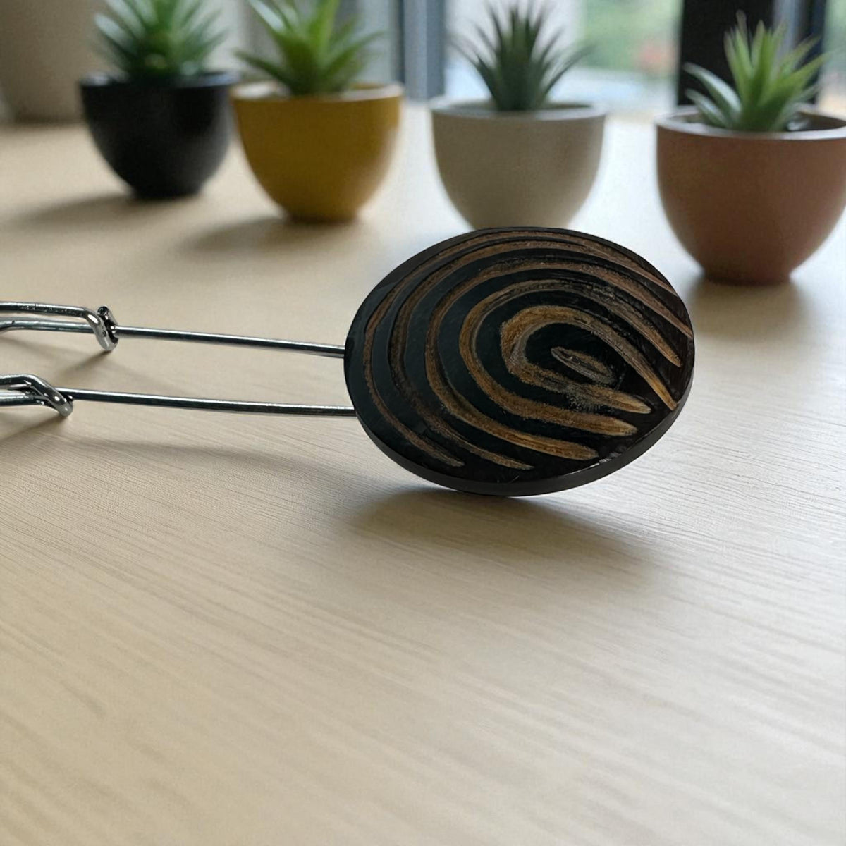 Ponchonadel mit Holz-Spirale auf hellem Tisch