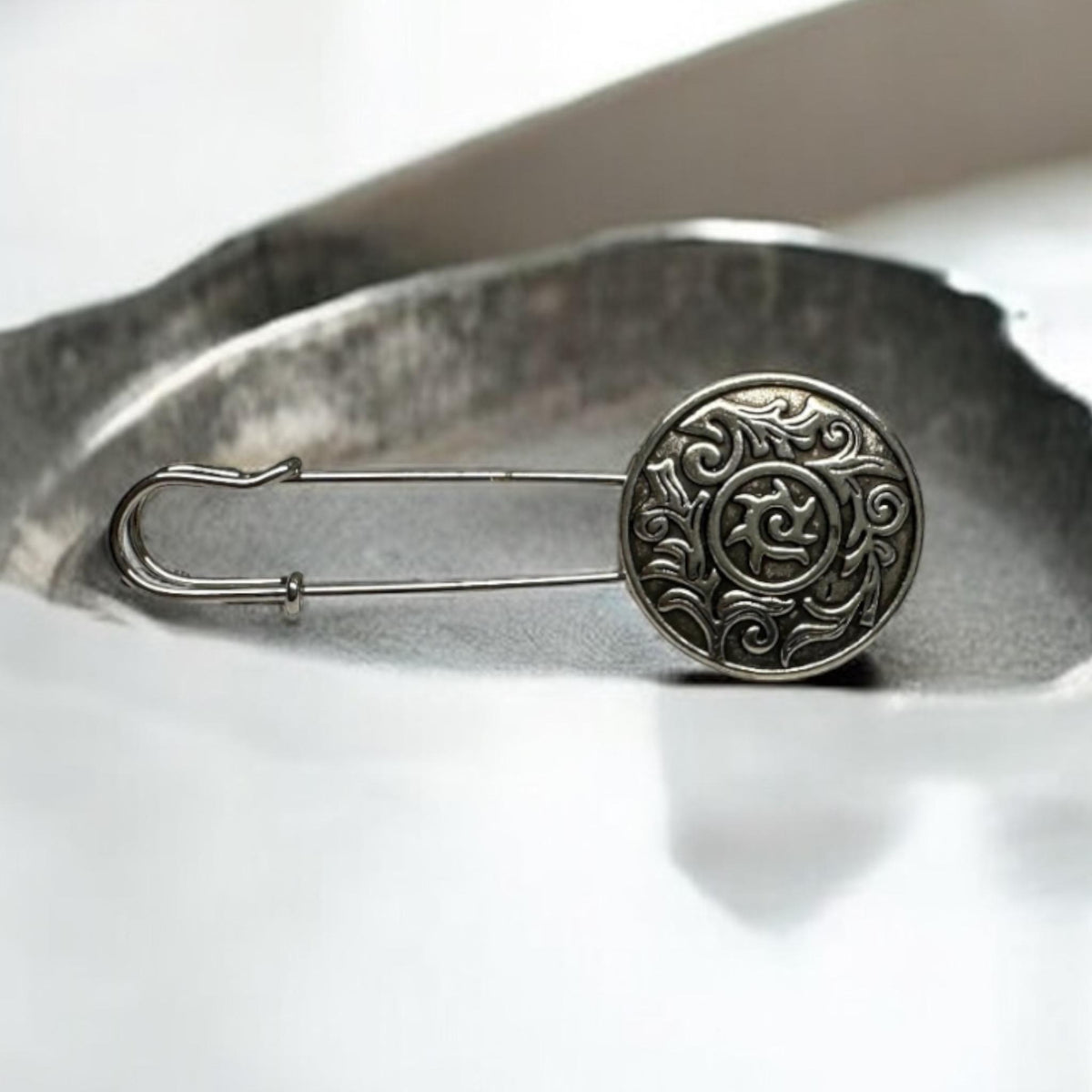 Ponchonadel mit keltischem Ornament auf hellem Untergrund