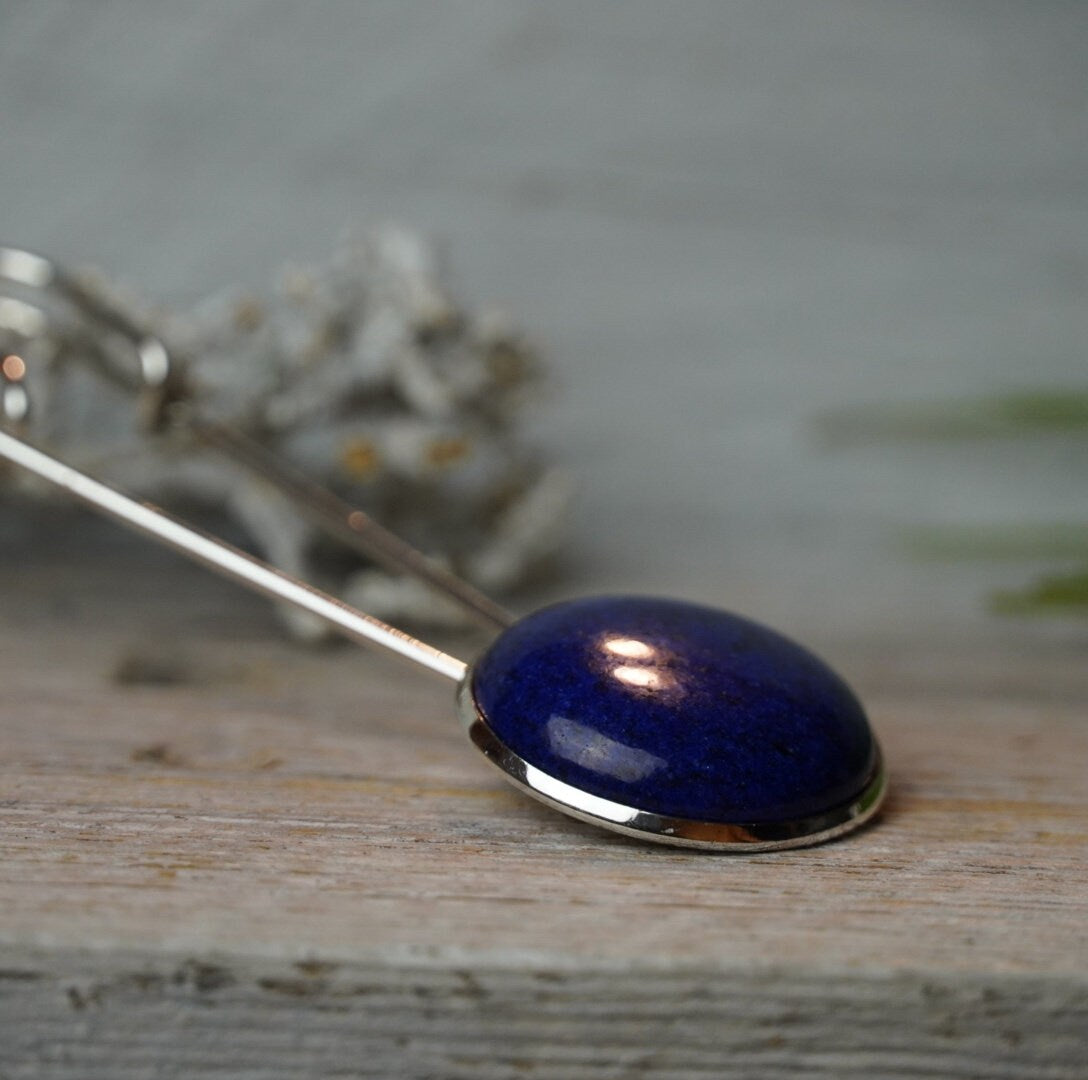 Seitliche Nahaufnahme des gewölbten Lapis Lazuli in silberfarbener Fassung