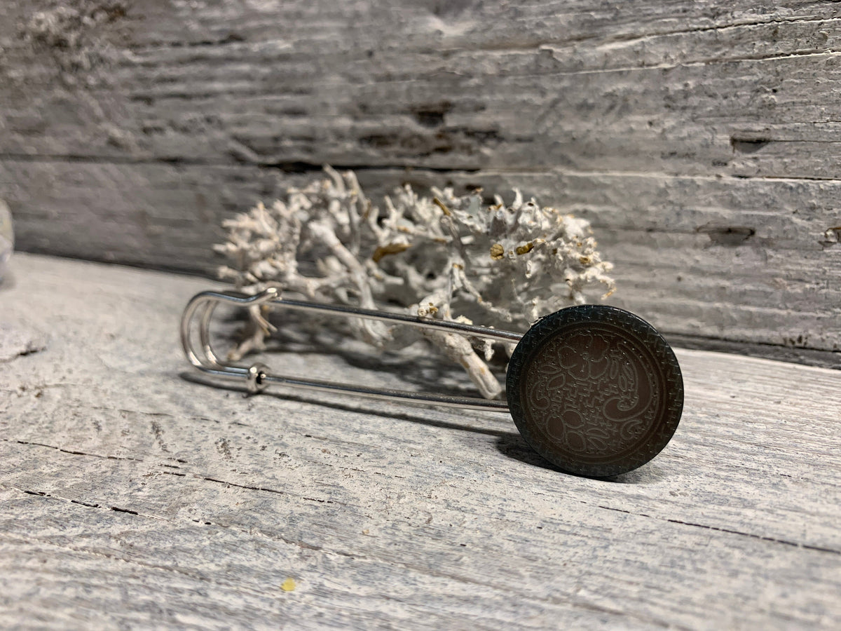 Nahaufnahme der grauen Perlmutt-Einlage mit graviertem Blumenornament an der Ponchonadel