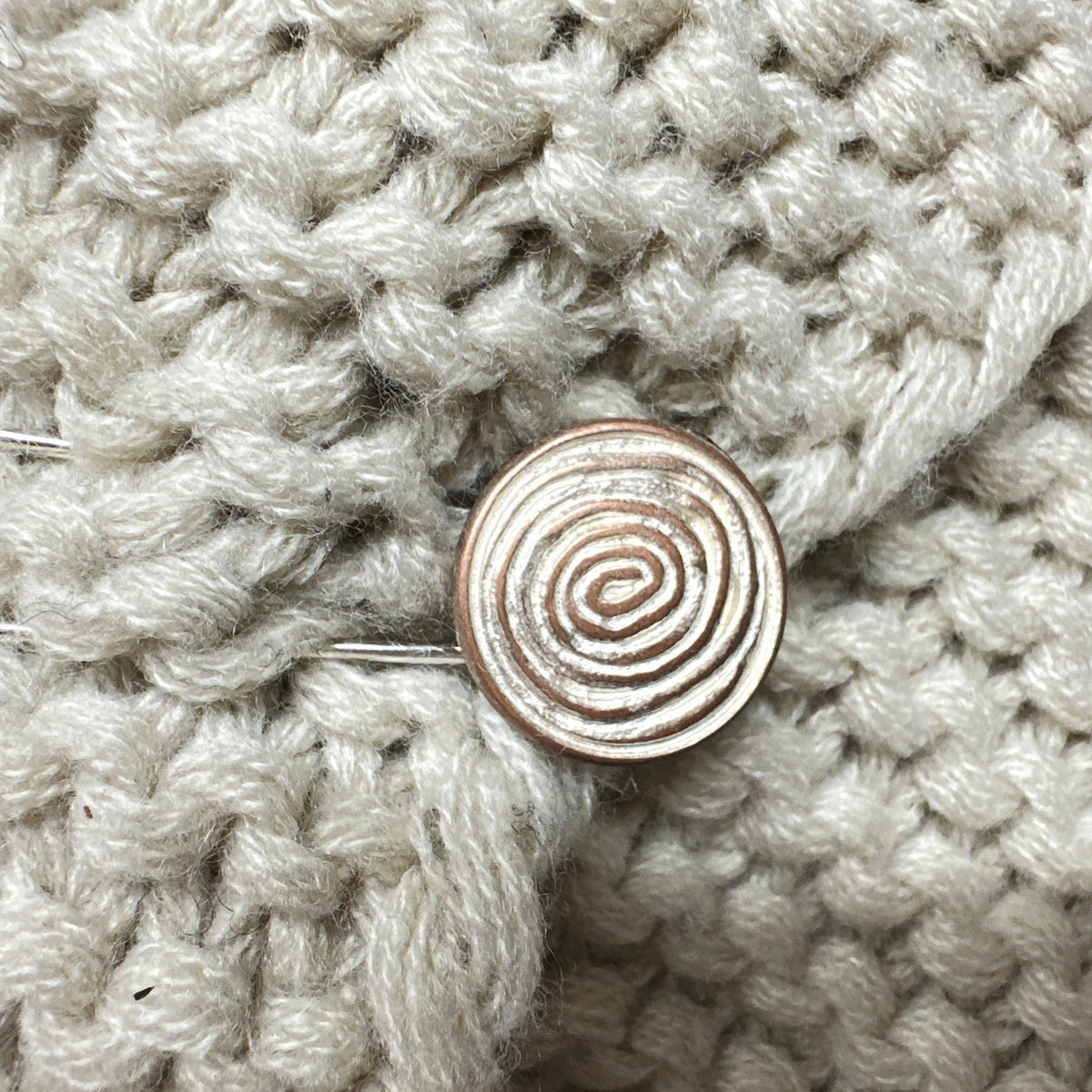 Ponchonadel mit Spiralmotiv auf cremefarbenem Grobstrick