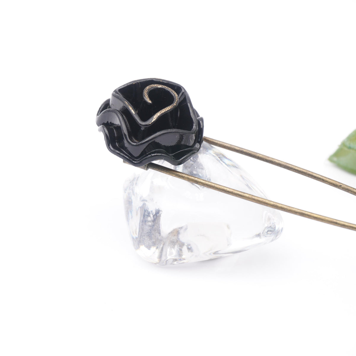 Nahaufnahme der schwarzen Rose mit goldfarbenem Rand auf einem Glasstein